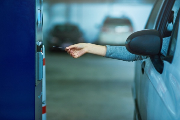 Parking,Lot,,Car,And,Hand,With,Ticket,Meter,For,Payment, Facturation électronique : quel sort pour les tickets de parking et de péage ?