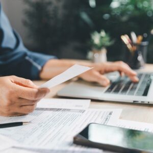 Tax,Preparation,At,Office,Desk,With,Hands,Holding,Receipt,And Impôt sur le revenu : remboursements ou prélèvements à venir