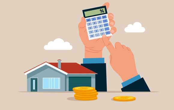 Hands,Holding,A,Calculator,And,Home.,Calculating,Property,Investment,Costs. Taxe foncière : les « éléments de confort » sous surveillance