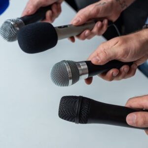 Close-up,Of,Four,Hands,Holding,Different,Microphones,,Suggesting,A,Press Facturation électronique : une tolérance pour les intermédiaires de presse ?