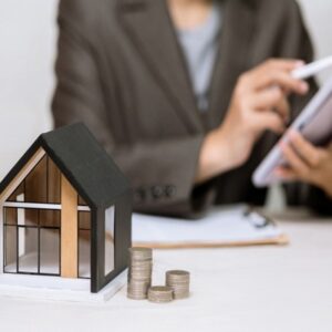 A,Model,House,And,Stacks,Of,Coins,Sit,On,A Sociétés immobilières cotées : dernier actif vendu, quel impact sur l’impôt sur les sociétés ?